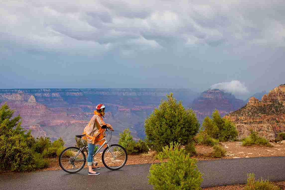 Female Biker stopped on bike path to look over the Grand Canyon