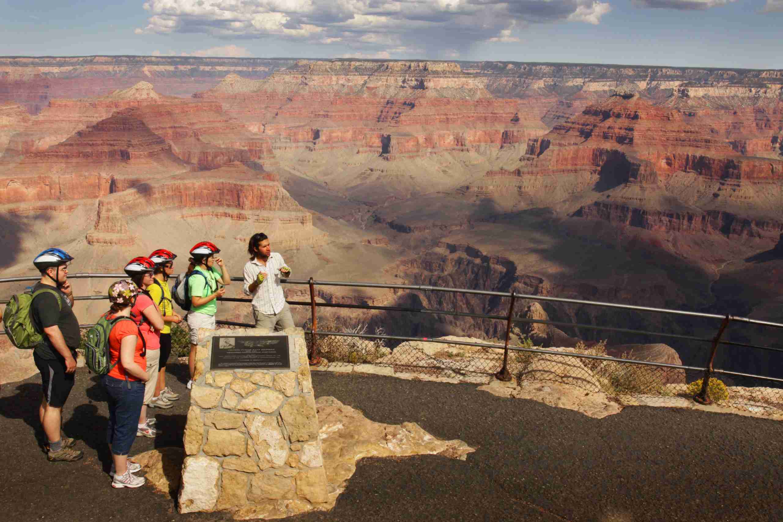 Guide sharing details with bikers about the upcoming bike ride while overlooking the Grand Canyon